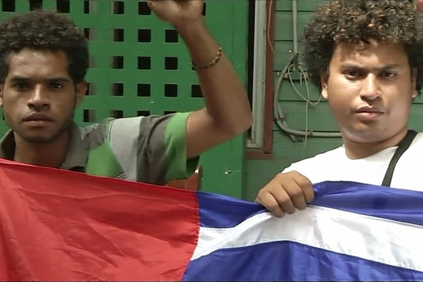 Two West Papuan activists hold the West Papuan flag in Port Moresby.