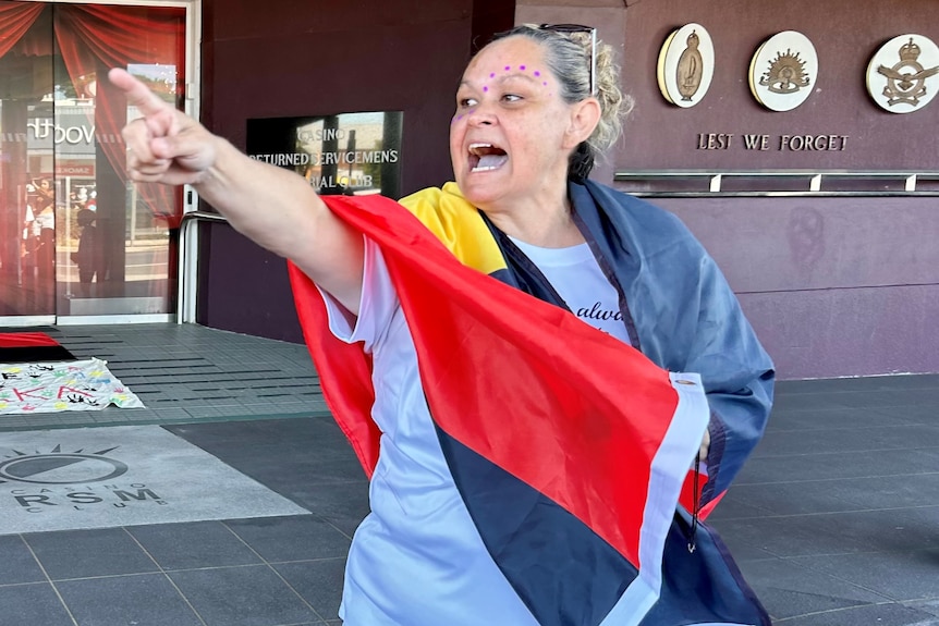 angry woman draped in aboriginal flag