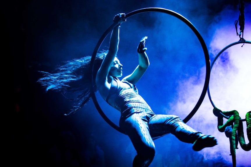 woman swinging through a hoop in animal make up