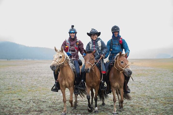 Three riders mounted on horses in the Mongol Derby.