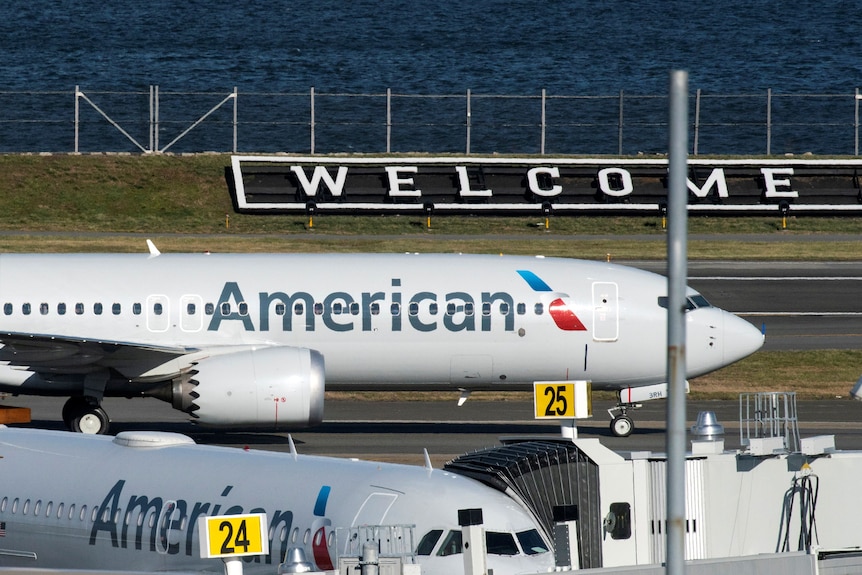 Un jet d'American Airlines atterrit devant un panneau 
