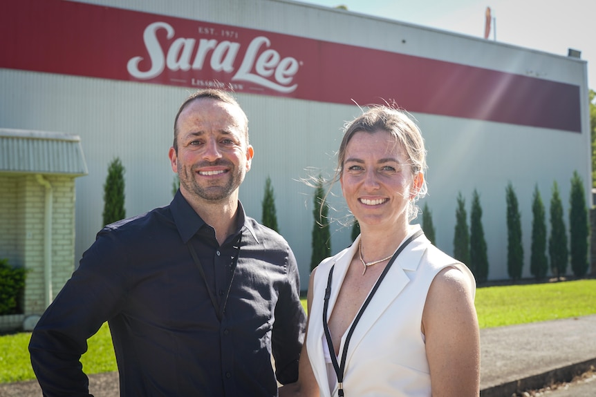 A man and woman stand outside the Sara Lee factory.