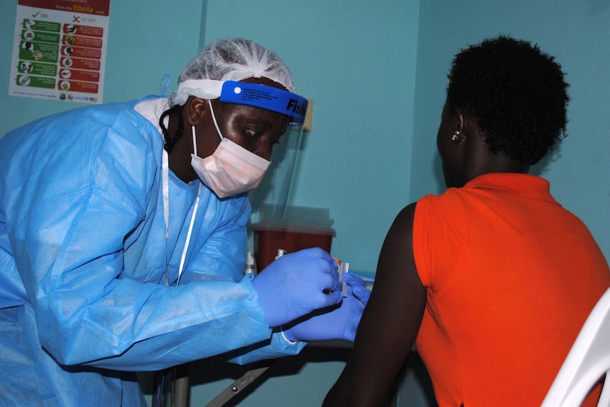 A health worker injects a woman with an Ebola vaccine during a trial in Monrovia, Liberia