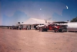 A truck sitting outside the Betoota Hotel in the 1990s towing a car