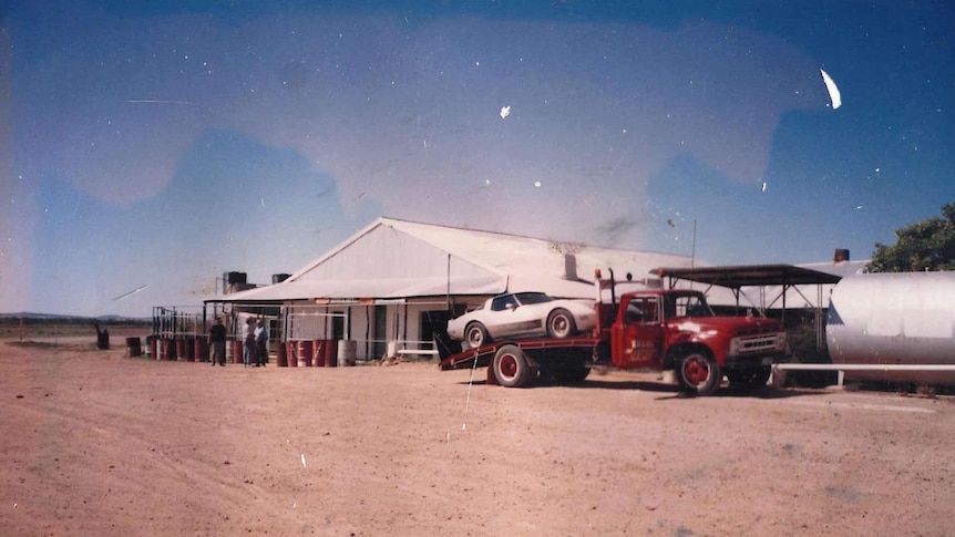 A truck sitting outside the Betoota Hotel in the 1990s towing a car