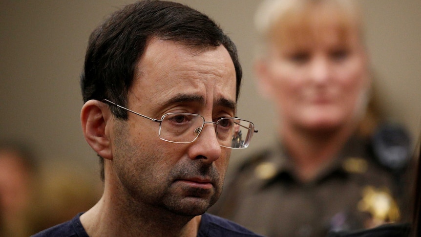 Larry Nassar stands in court.