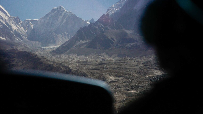 Snowy mountains through the front window of a chopper