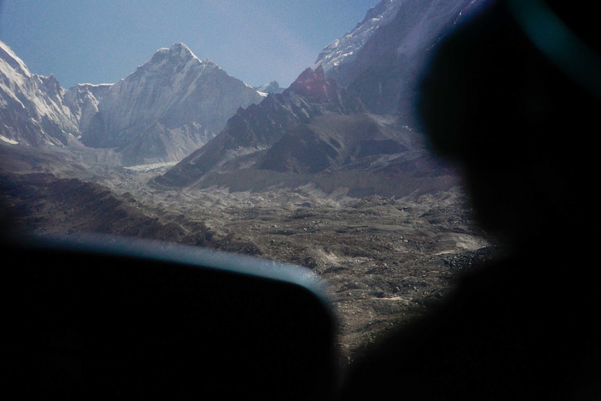 Snowy mountains through the front window of a chopper