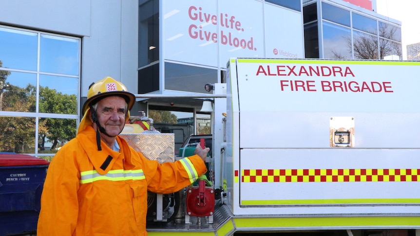 CFA volunteer standing in from of truck and blood donation centre