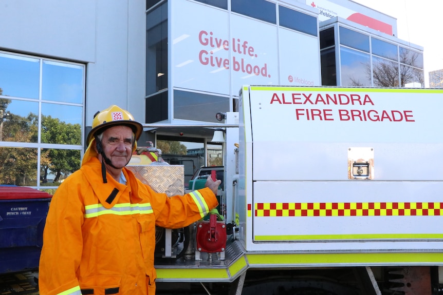 CFA volunteer standing in from of truck and blood donation centre