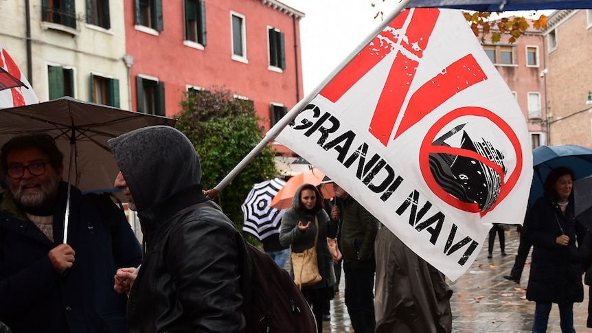 A protester holding a flag with the slogan No Grandi Navi