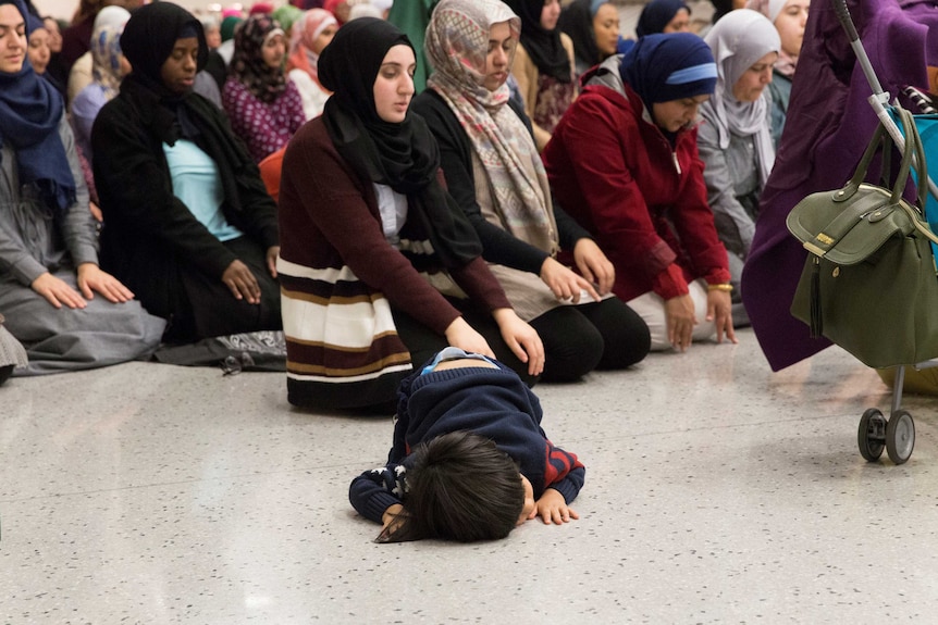 People gather to pray during a protest against the travel ban at Dallas Fort Worth airport.