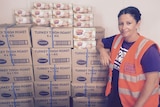 a woman standing next to turkeys in boxes