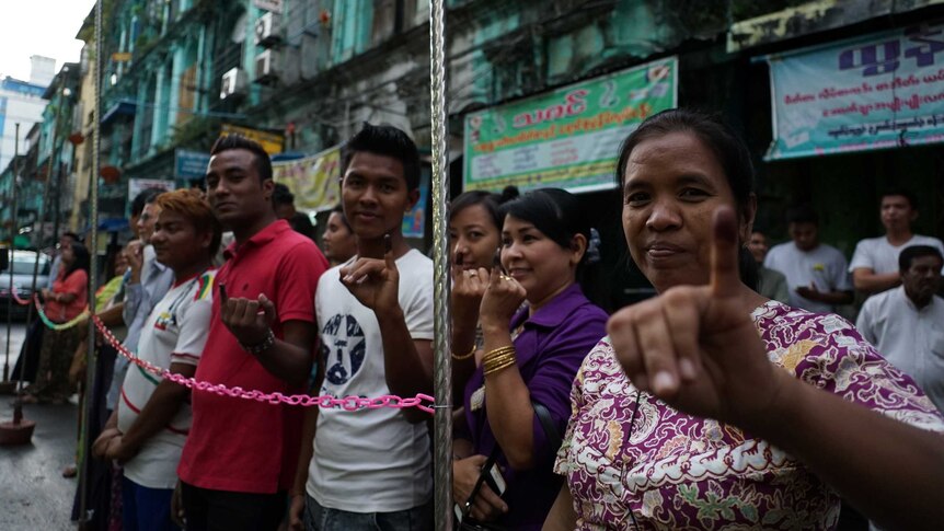 Voters show their inked fingers after voting.