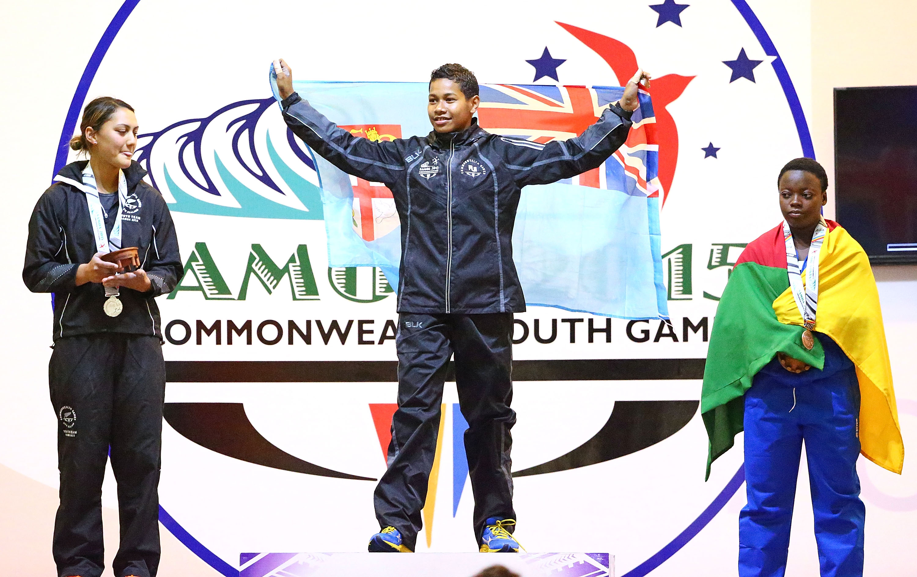 Three young women on a podium.