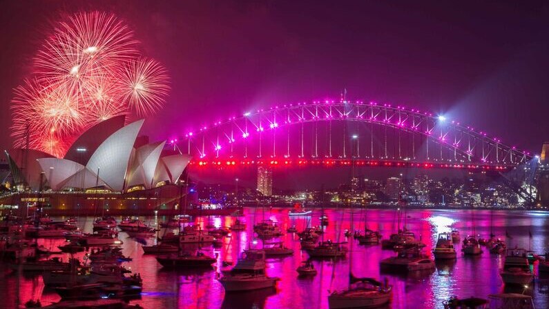 Fireworks light Sydney Harbour up in pink on New Year's Eve.
