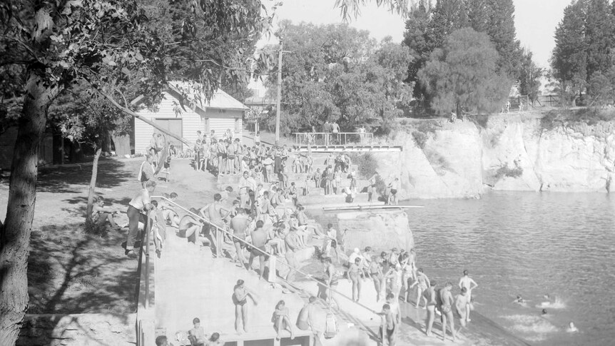 A black and white photo of people swimming at Surrey Dive swimming hole in the 1930s.