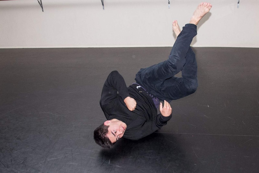 Close up of a young man just above the floor in a breakdancing move