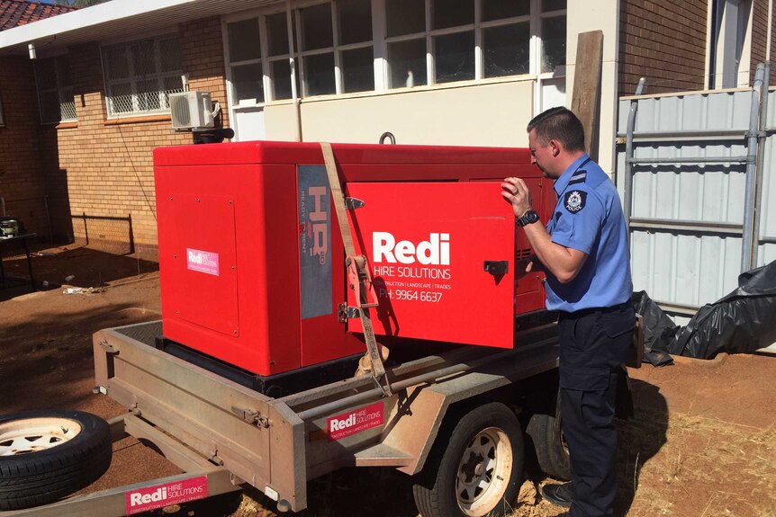 Sergeant Chris Martin opens generator hired by police station.