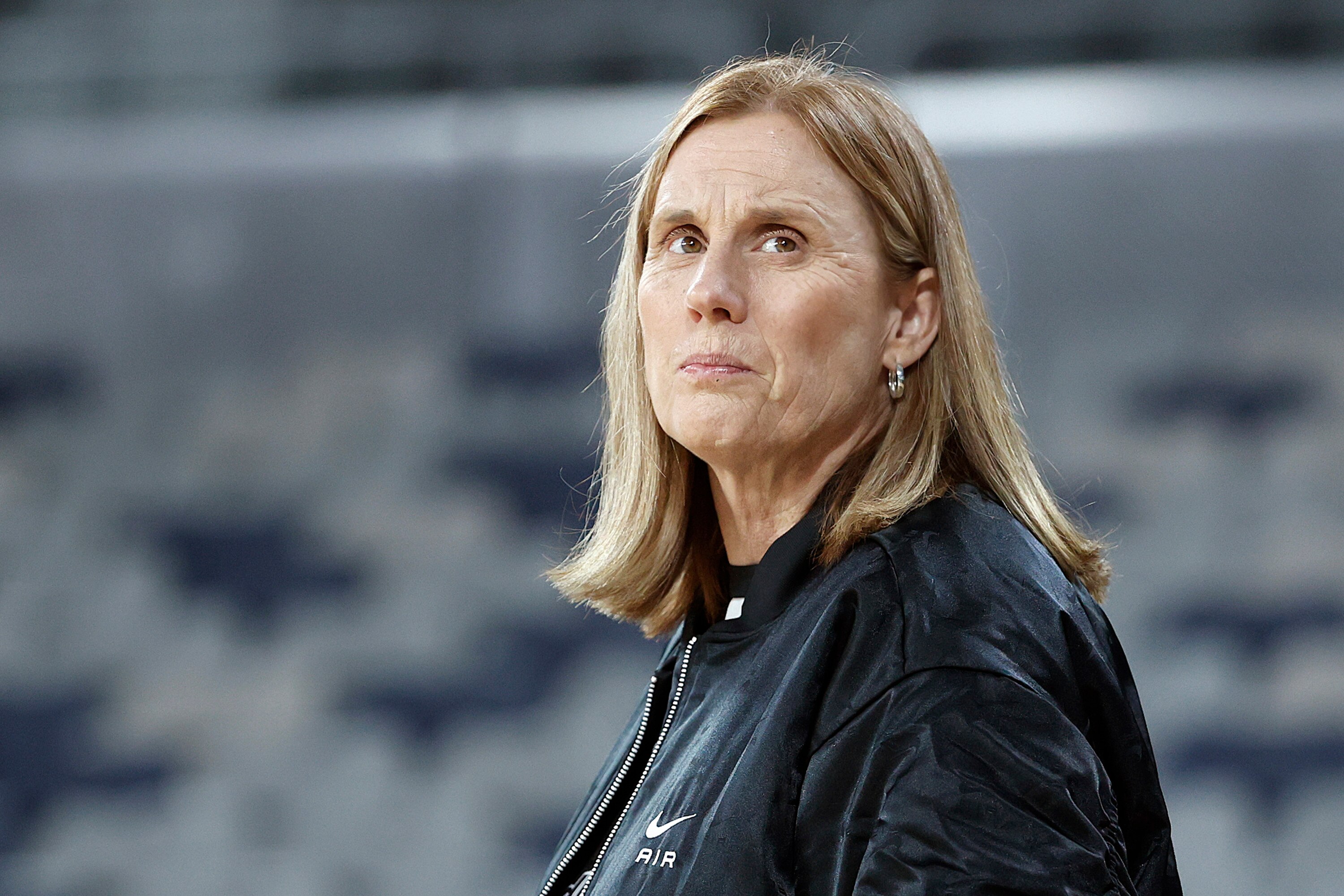 A netball coach looks up at the stands ahead of her team's final game in the league.