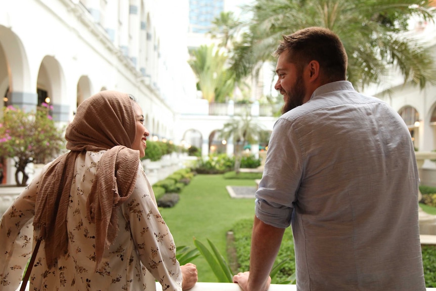 Max and Shaffira looks onto a garden with their backs facing the camera.