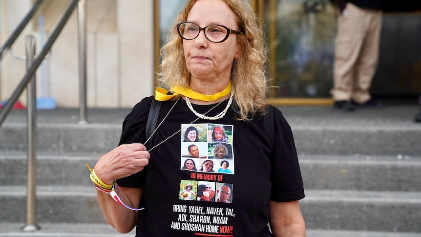 A woman stands with a protest t-shirt 