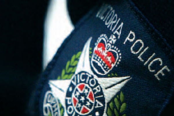 A Victoria Police badge is shown on a police uniform.