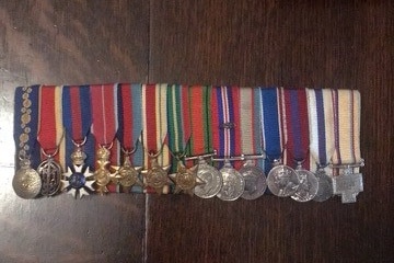 War medals in a row on a wooden table.