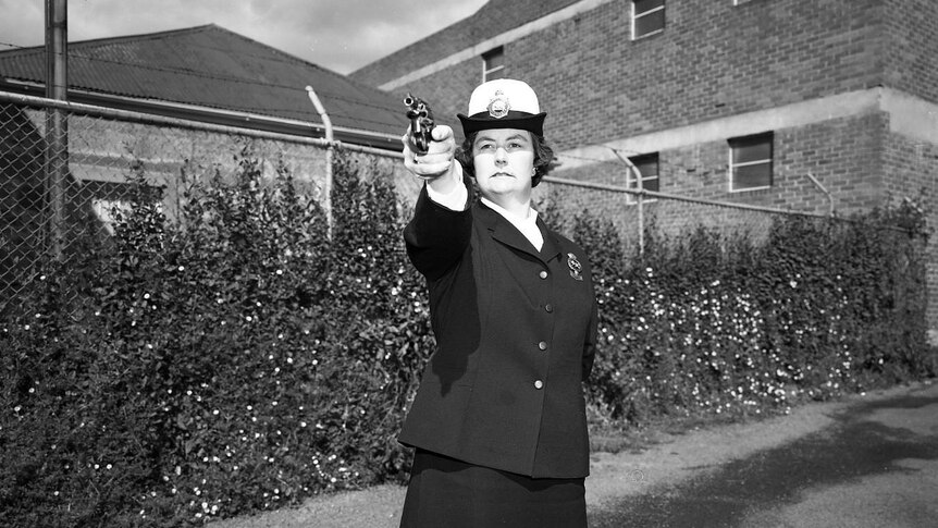 Sergeant Beth Ashlin pointing a pistol taken in the 1970s.