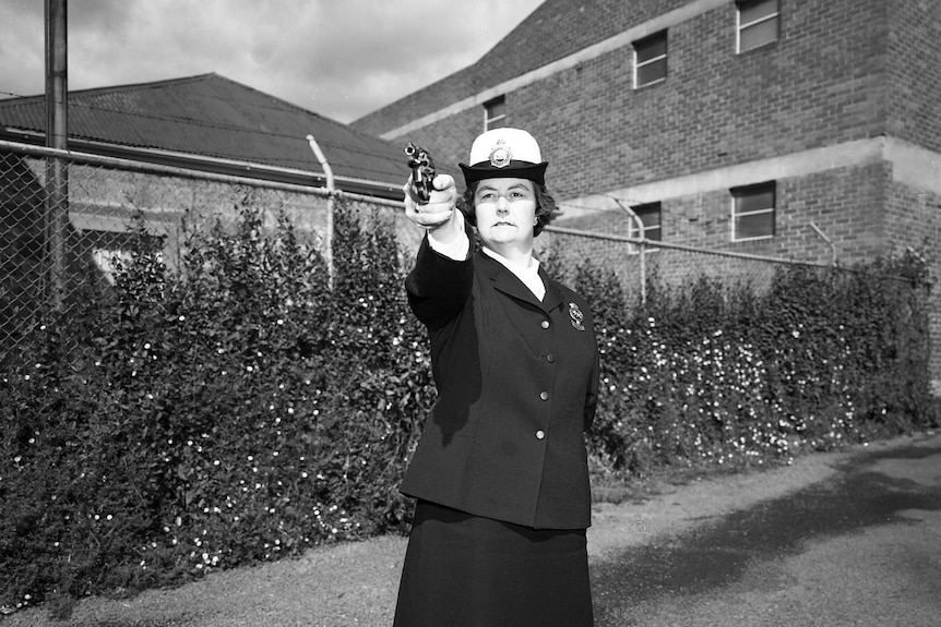 Sergeant Beth Ashlin pointing a pistol taken in the 1970s.