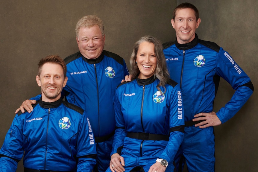 William Shatner and three other members of Blue Origin's second human spaceflight pose for a photo in astronaut gear.