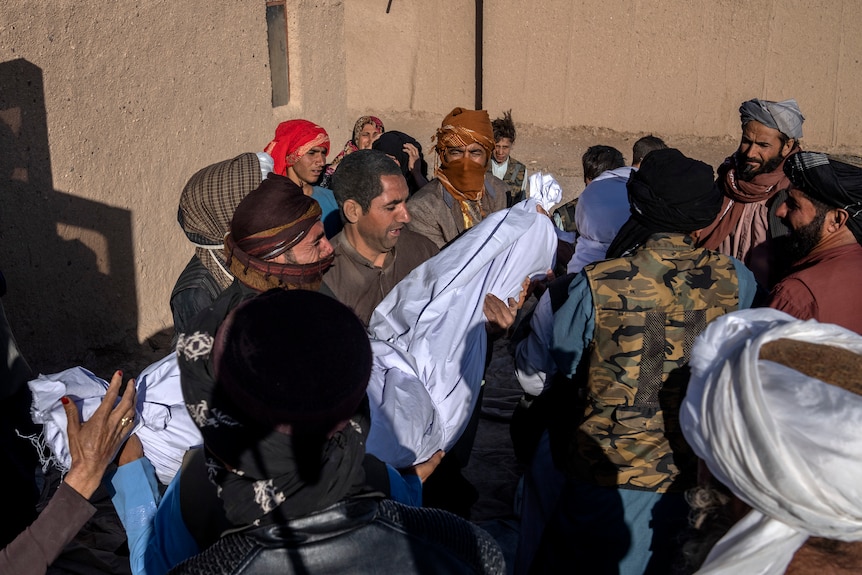 Afghan people carry the body of their relative killed in an earthquake.