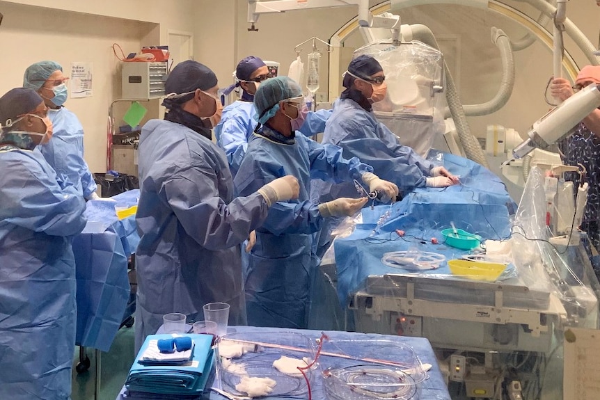 A team of surgeons and medical staff in an operating theatre