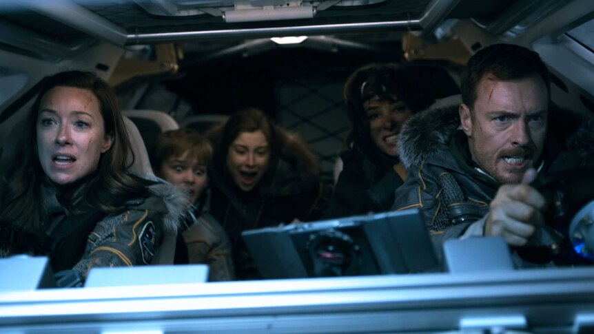 The Robinson family in a space vehicle  with the two children screaming