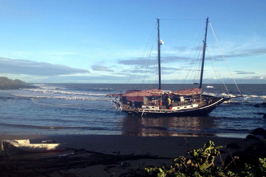 A yacht sits on Bargara beach after being blown there by the remains of ex-tropical cyclone Oswald.