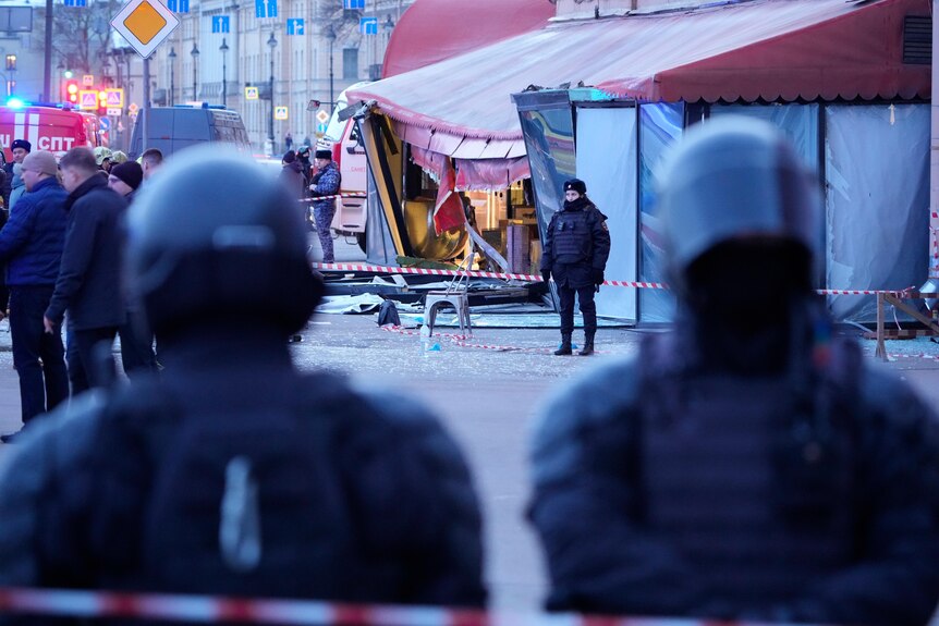 Police stand outside the site of the cafe blast. 