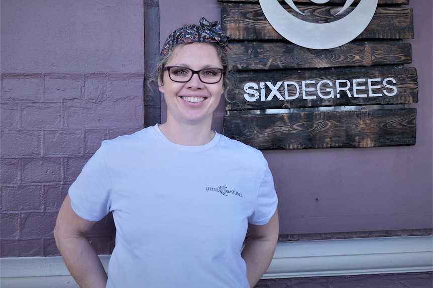 a woman standing in front of a bar