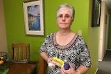 Vaginal mesh patient Jan Maessen holds medication as she discusses her chronic pain