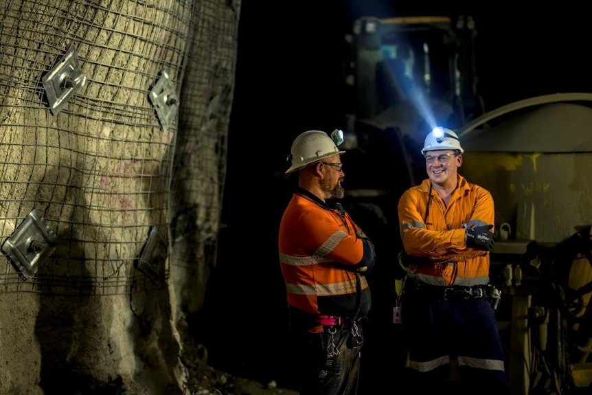 Two men standing in an underground mine shaft