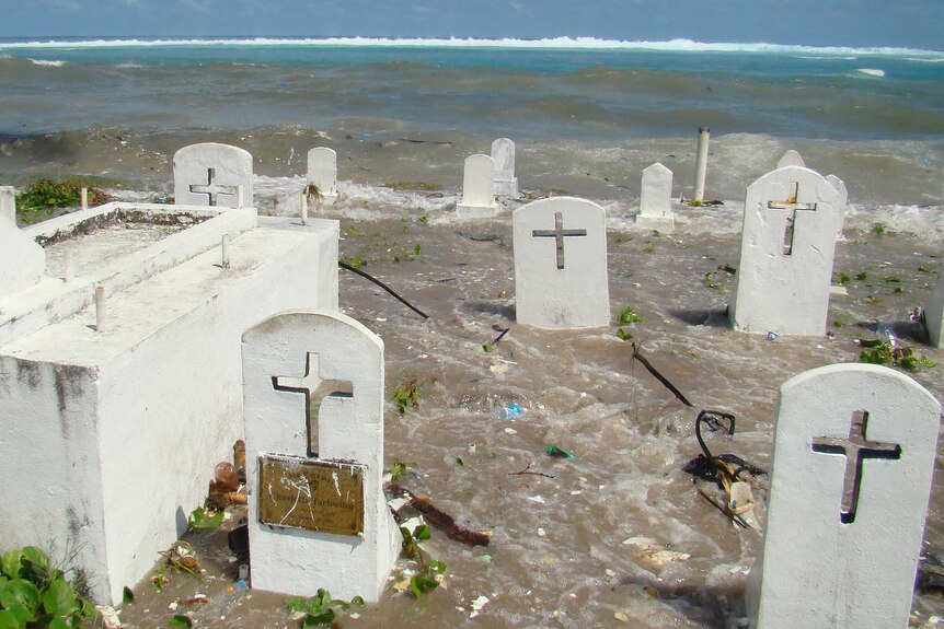 High tides and ocean surges flood a cemetery on the shoreline in Majuro Atoll.