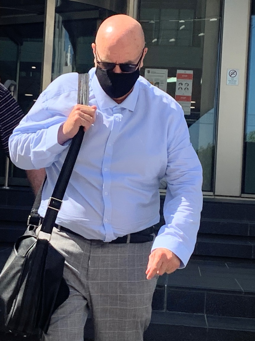 Simon Tugwell leaves court wearing a mask and sunglasses