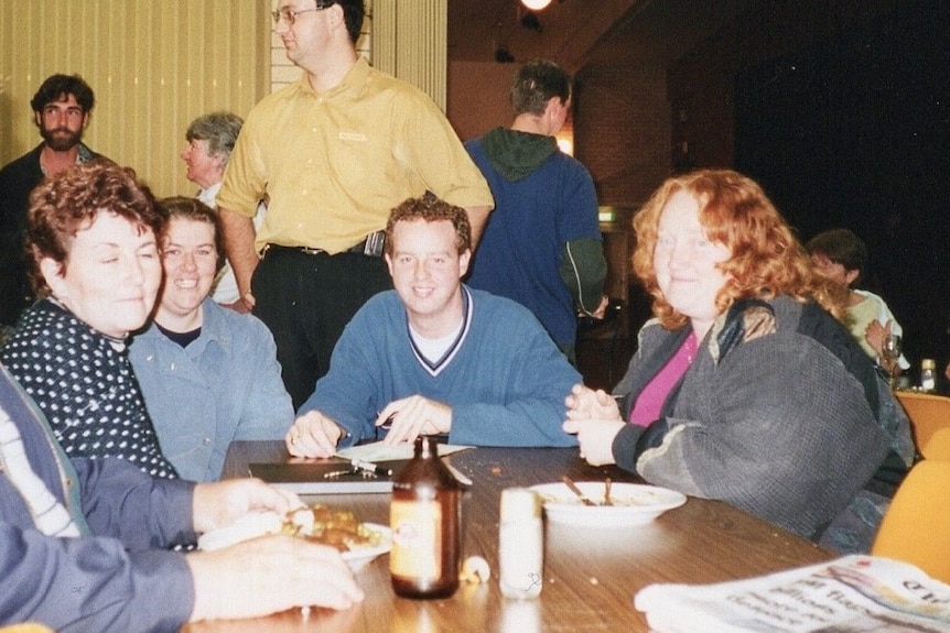 Survivor Richard Tempest sitting with volunteers at the Childers Cultural Centre in June 2000