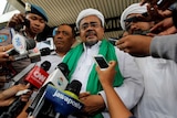 Rizieq Shihab speaks to a crowd of reporters