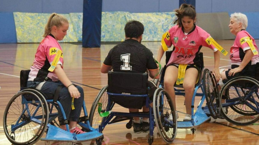 Wheelchair rugby league players compete on the field