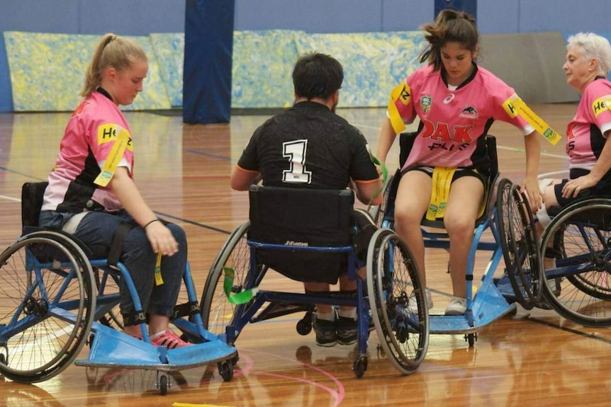 Wheelchair rugby league players compete on the field