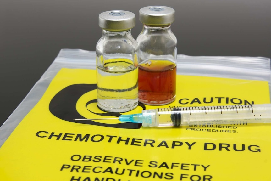 Two vials of liquid on a yellow plastic chemo bag
