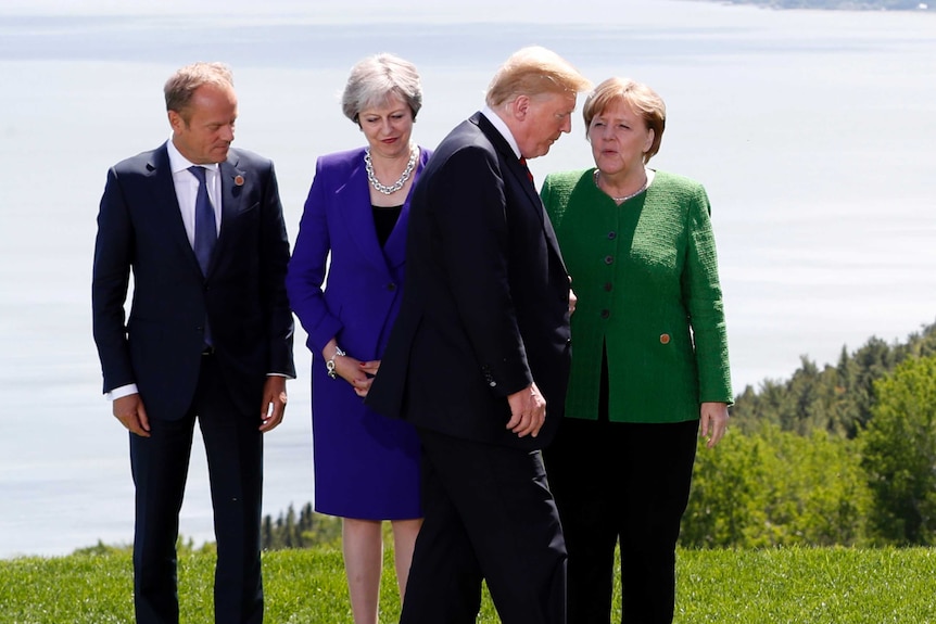 Trump walks past other leaders during a family photo at G7 summit.