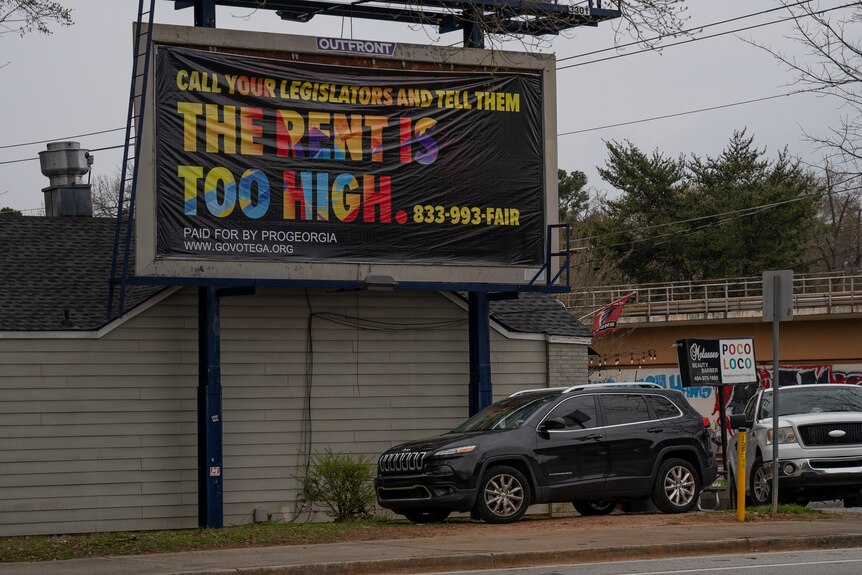 A billboard reading "The Rent is Too high"