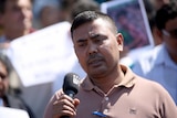 Headshot, man speaking into microphone.