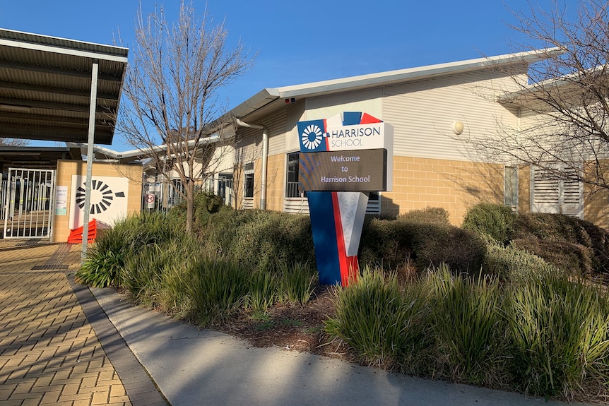 Exterior of a school campus with a sign that reads Harrison.